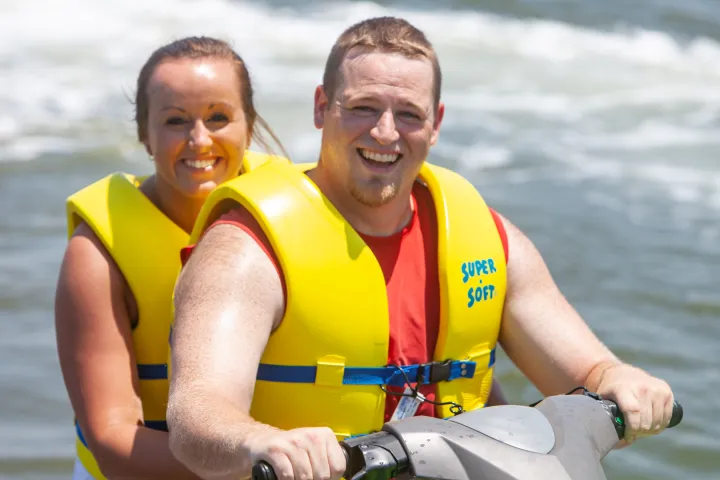 a couple of people that are standing in the water