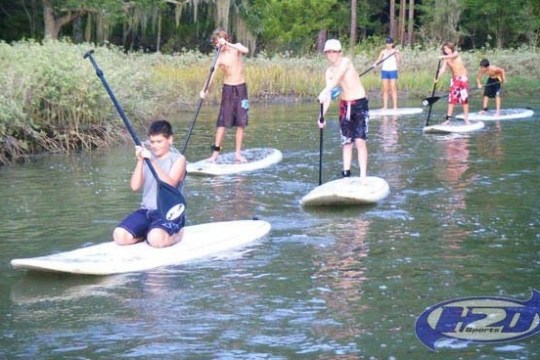 a group of people riding on the back of a boat in the water