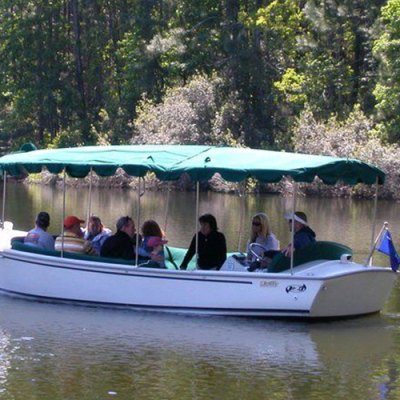 a group of people riding on the back of a boat in the water