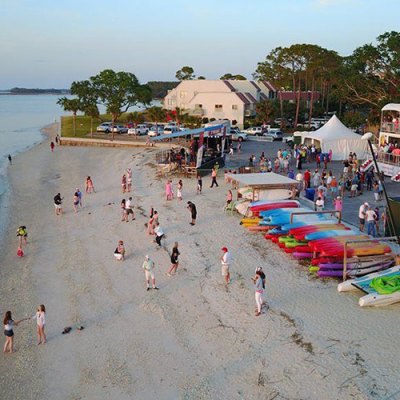 a group of people on a beach near a body of water