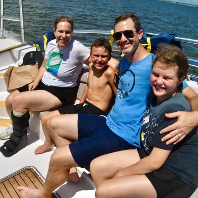 a group of people sitting on a bench next to a body of water