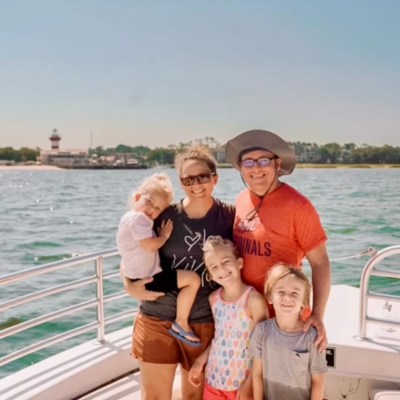 a person standing in front of a boat next to a body of water